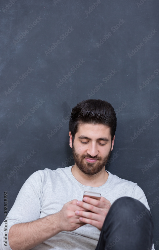 Casually handsome. Handsome young arabic man holding cell phone