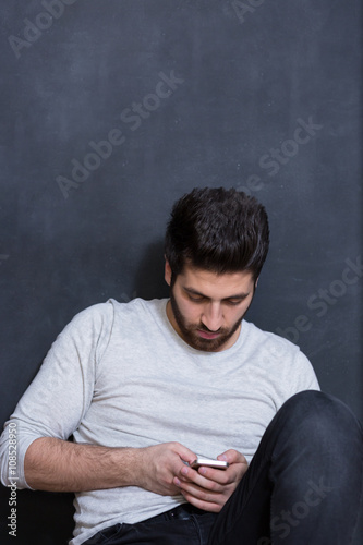 Casually handsome. Handsome young arabic man holding cell phone
