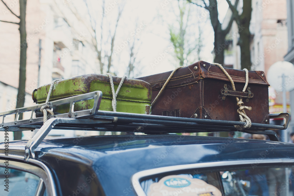 Vintage suitcase on an old car roof rack. Stock Photo Adobe Stock