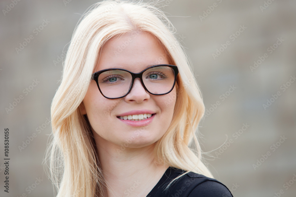 Young blonde girl with glasses smiling Young blonde girl with glasses smiling