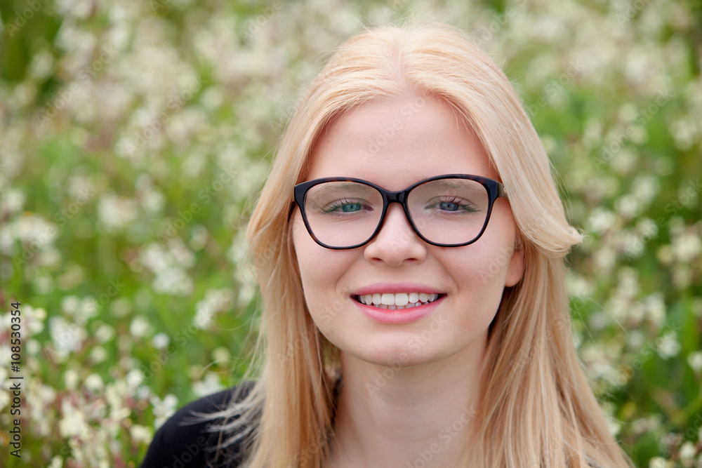 Blonde girl with glasses surrounded by flowers Blonde girl with glasses surrounded by flowers