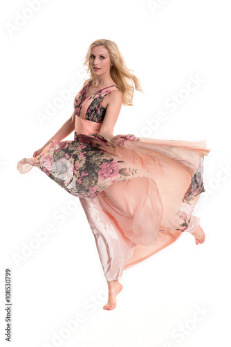 Blonde Frau schwebt im Abendkleid auf Zehenspitzen- freigestellt 