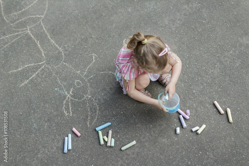 Sidewalk chalk drawing of preschooler girl wearing pink ruffle skirt