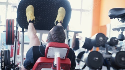Wallpaper Mural Man exercising on leg press machine Torontodigital.ca