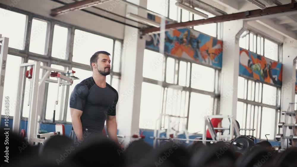 Strong man - bodybuilder with dumbbells in a gym, exercising with a barbell Strong man - bodybuilder with dumbbells in a gym, exercising with a barbell