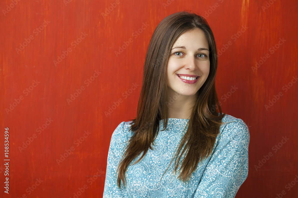 Portrait of a beautiful young woman in a turquoise dress on red Portrait of a beautiful young woman in a turquoise dress on red