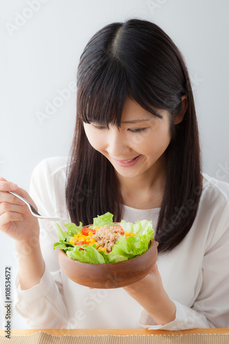 サラダを食べる女性、トマト、レタス、ツナ