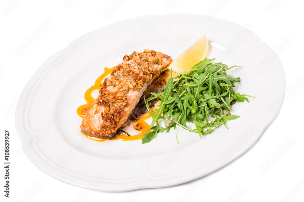 Baked salmon fillet with walnuts and arugula.