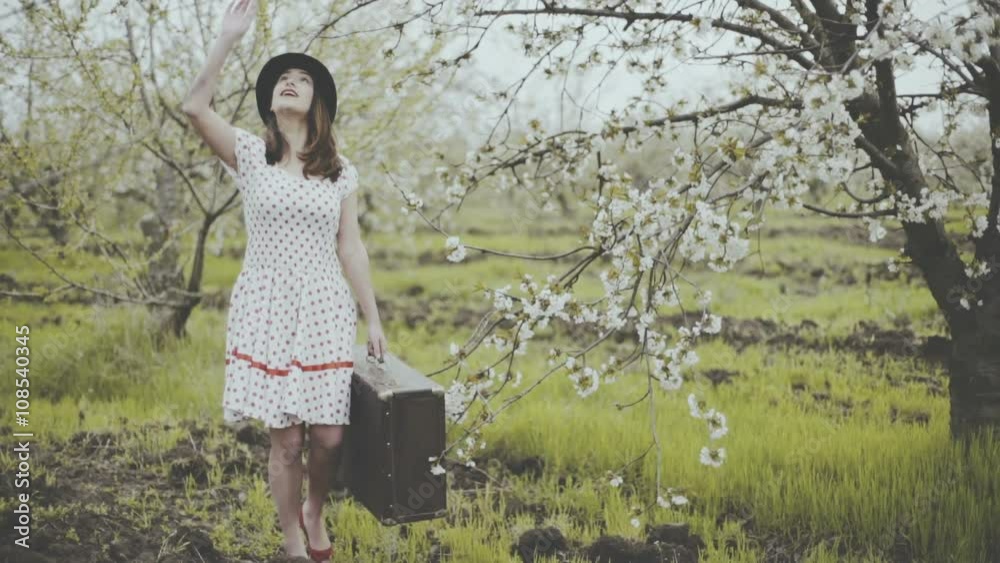 young woman dressed in retro style posing in blooming garden slow motion young woman dressed in retro style posing in blooming garden slow motion