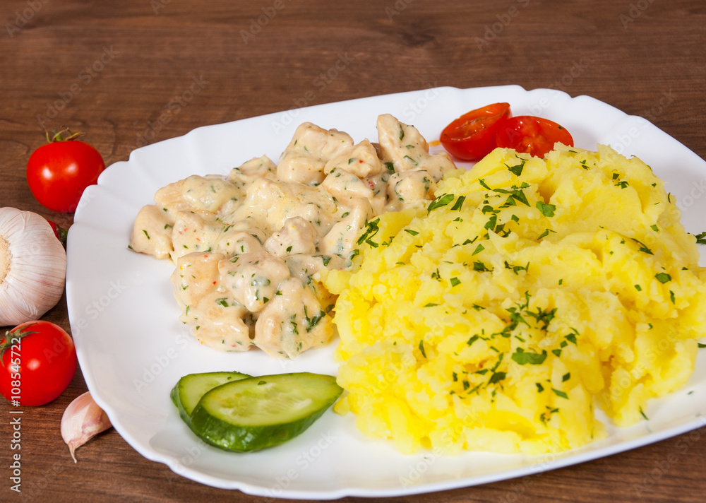 chicken breast in a creamy sauce with mashed potatoes in a plate on wooden table chicken breast in a creamy sauce with mashed potatoes in a plate on wooden table