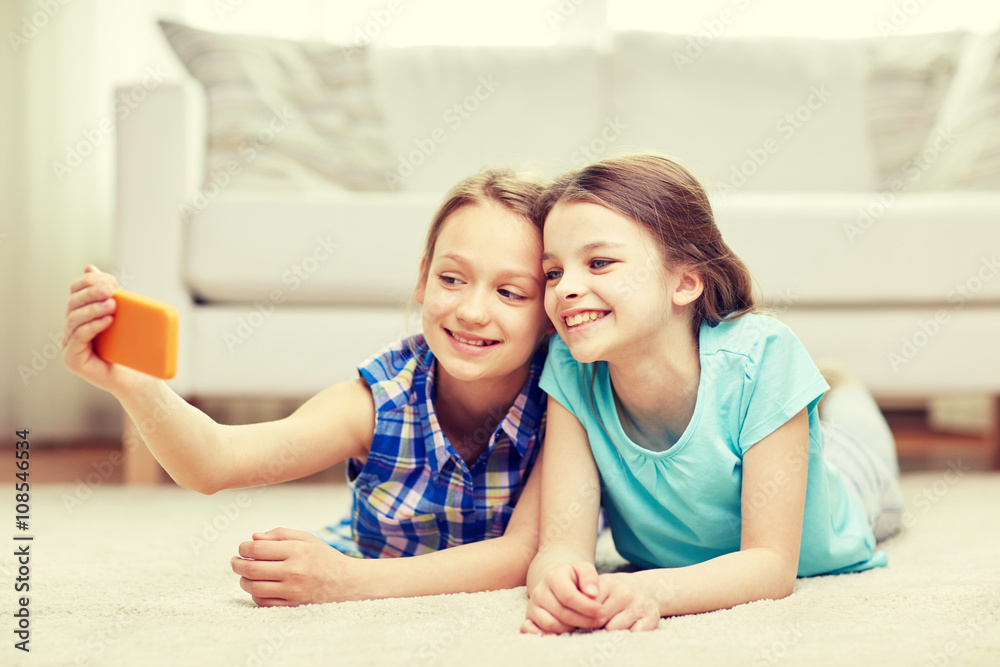 happy girls with smartphone taking selfie at home happy girls with smartphone taking selfie at home
