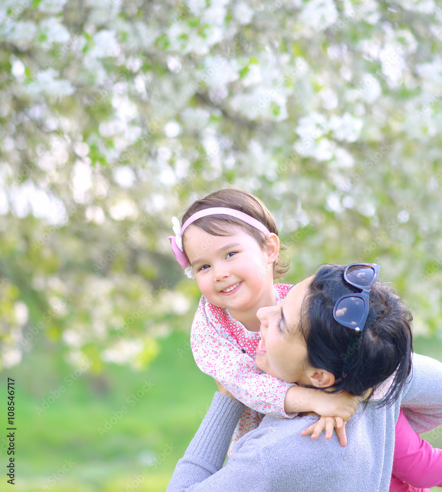 Mother and little daughter playing together in a park Mother and little daughter playing together in a park