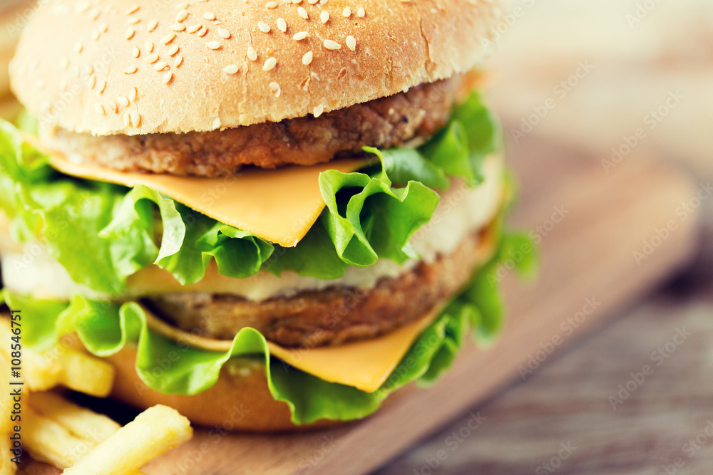 close up of hamburger or cheeseburger on table close up of hamburger or cheeseburger on table