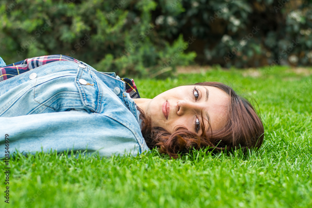 beautiful young woman resting on the grass