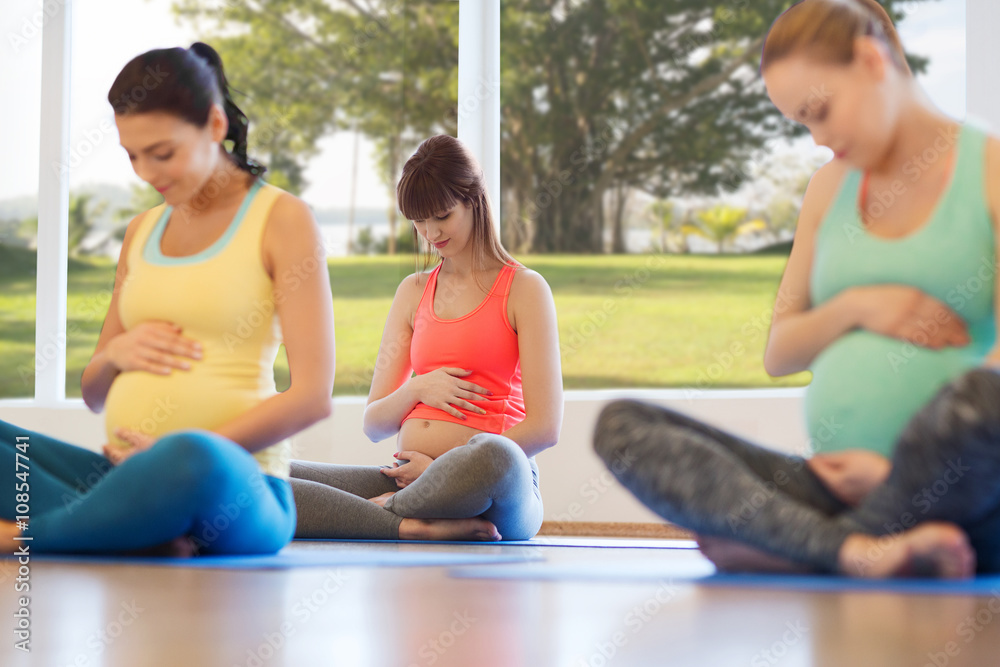 happy pregnant women exercising yoga in gym happy pregnant women exercising yoga in gym