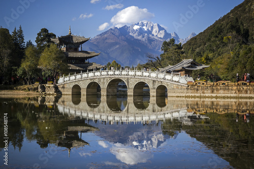 Chinese stone bridge in the Black Dragon Pool, Lijiang, China with a backdrop of the Jade Dragon Snow Mountain