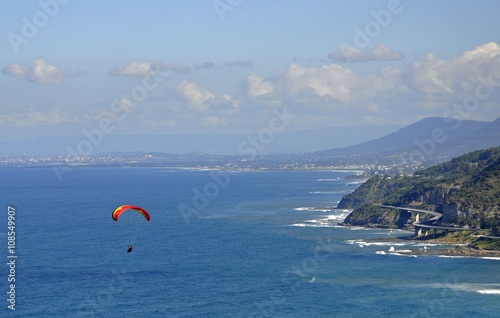 Paragliding at Stanwell Park, Sea Cliff Bridge and Wollongong in the background 