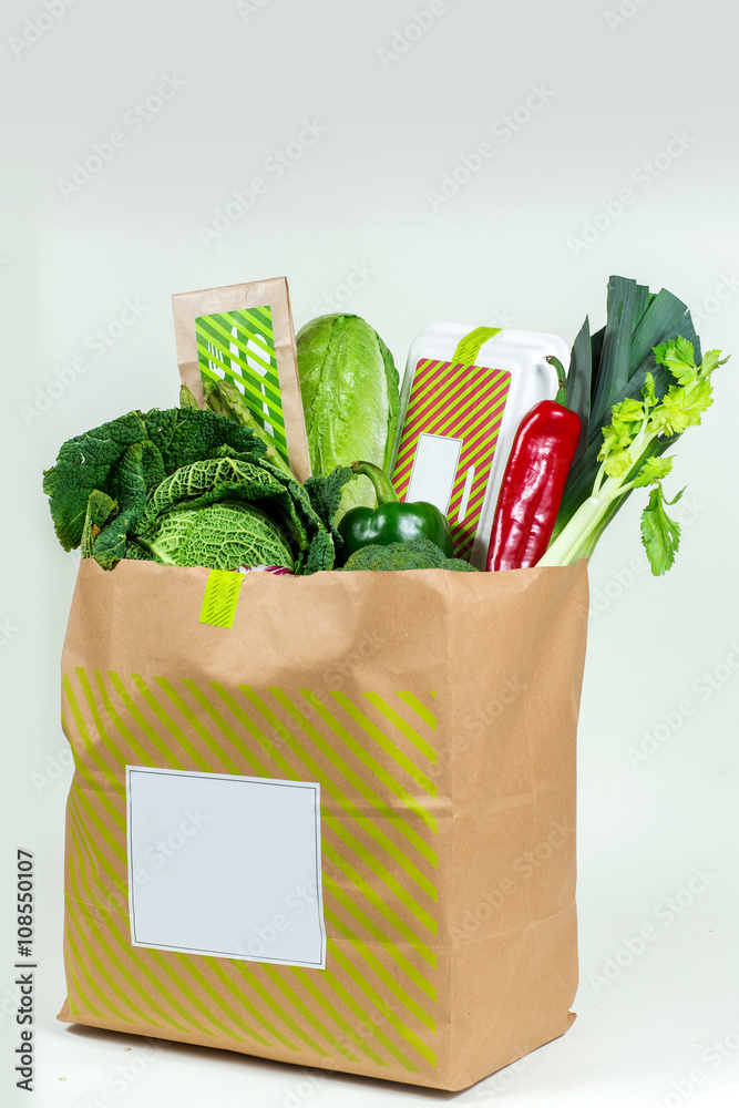 Naklejka Various fresh greens, vegetables and white box in paper bag