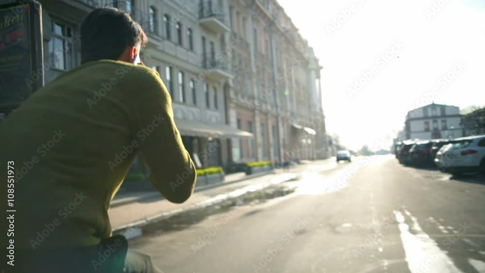 man rides a bike and talks on the phone back view slow motion man rides a bike and talks on the phone back view slow motion