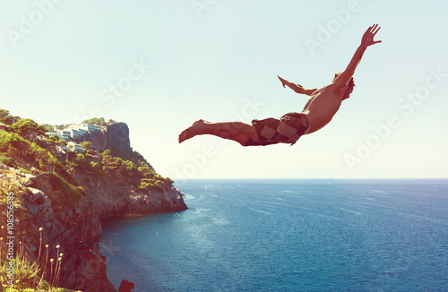 Mann springt von Klippe ins Meer