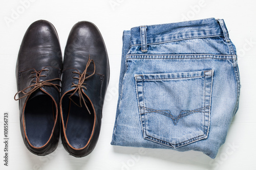 still life with shoes, jeans on white wooden background