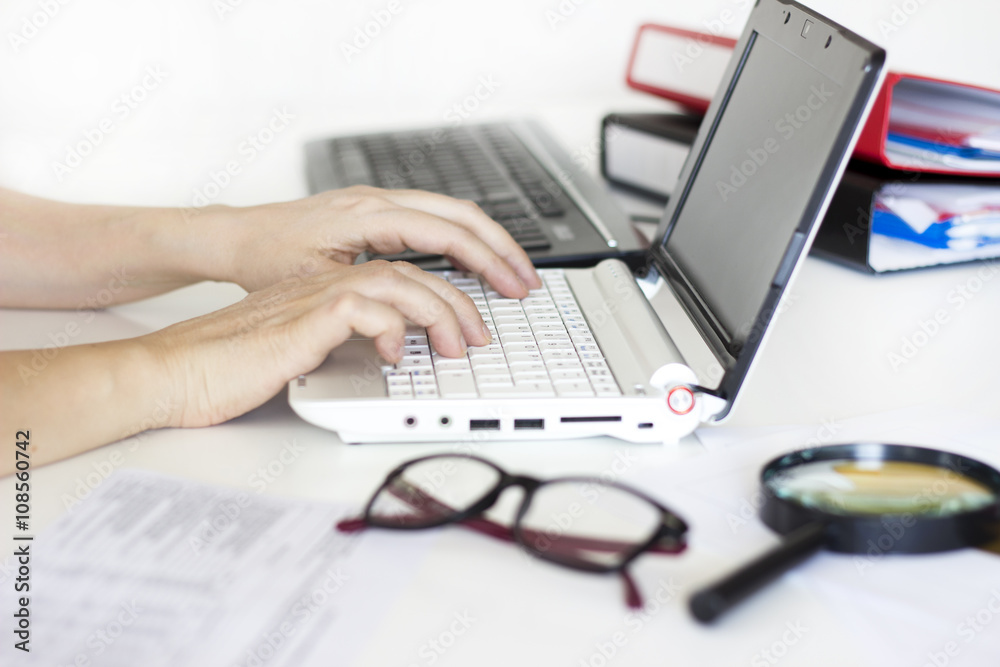 Businesswoman using laptop and calculator in the office Businesswoman using laptop and calculator in the office