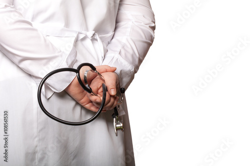 The doctor put his hands with stethoscope behind his back on a w