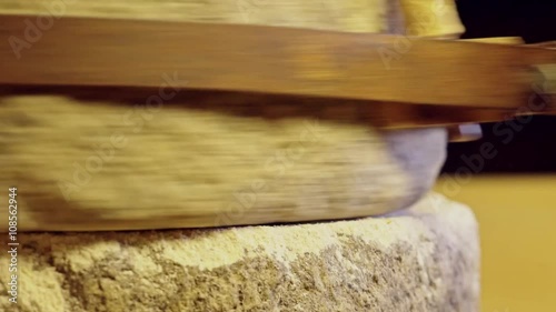 Close-up shot of historic hand-driven millstone grinding wheat