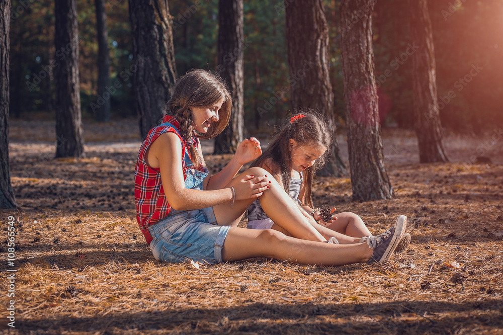 two Girl in a pine forest. toned. soft light effect. childhood, leisure, friendship and people concept. walks in the woods on a sunny autumn day. Children playing outdoors. Happy family. series two Girl in a pine forest. toned. soft light effect. childhood, leisure, friendship and people concept. walks in the woods on a sunny autumn day. Children playing outdoors. Happy family. series