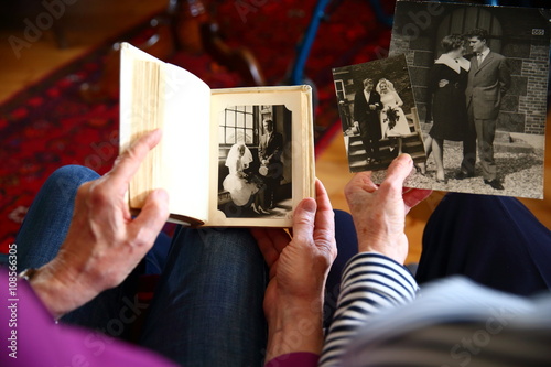senior/ elderly couple looking at  their wedding photo's together