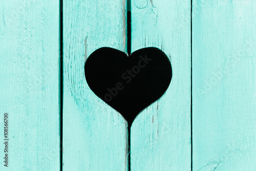 wooden background from old boards with a window in the shape of heart 