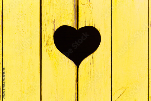 wooden background from old boards with a window in the shape of heart 