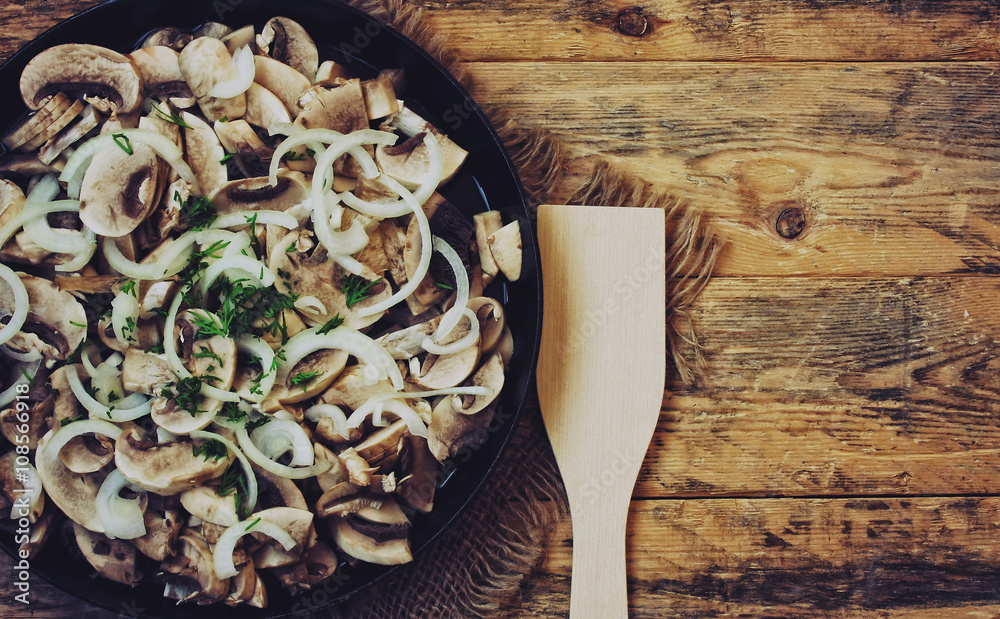 fresh sliced champignon and onions in frying pan