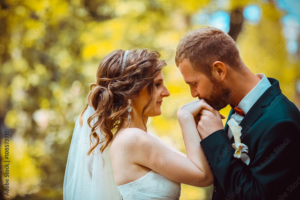 Elegant bride and groom posing together outdoors on a wedding day Elegant bride and groom posing together outdoors on a wedding day