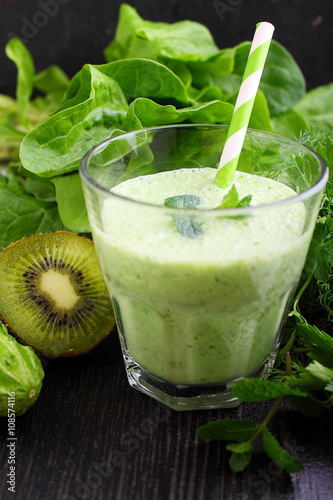 A glass of smoothie with green vegetables and spinach