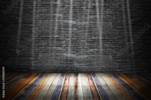 light in dark room with colorful wooden floor and grunge stone wall