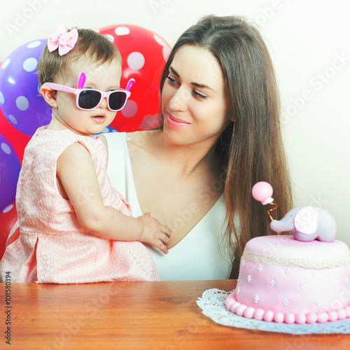 Mother with funny baby celebrating first birthday. Cake. photo