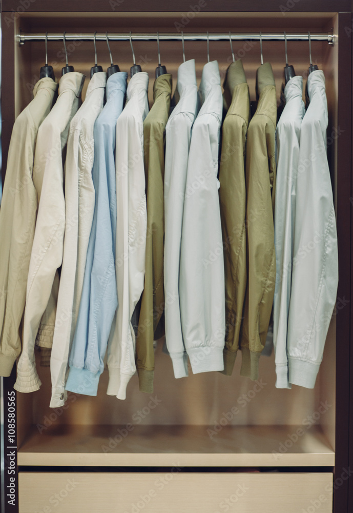 Colorful male jackets in row in a hanger