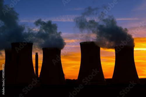 Silhouette of power plant at sunset