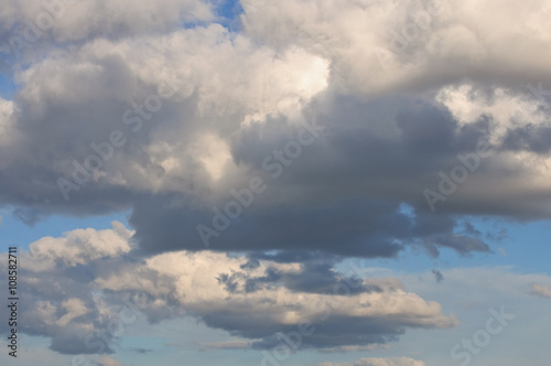 weiße und graue Wolken in einem blauen Himmel an einem sonnigen Tag im April photo