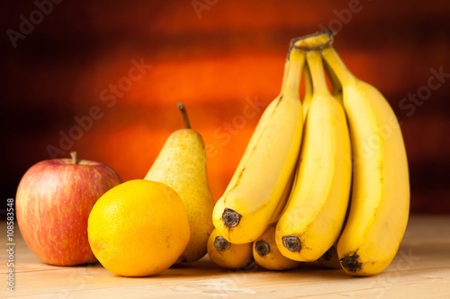 Fruit on the table - bananas pear apple and lemon wo a wooden de