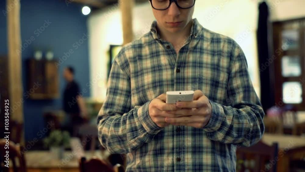 Happy boy standing in the cafe and texting on smartphone, steadycam shot
Happy boy standing in the cafe and texting on smartphone, steadycam shot