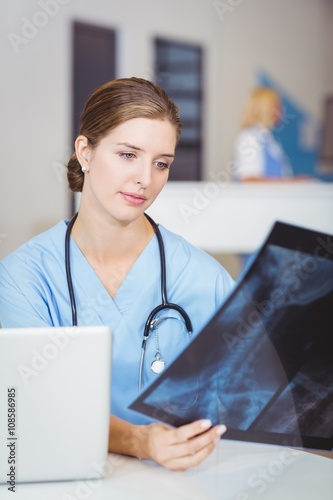 Female doctor holding X-ray at hospital