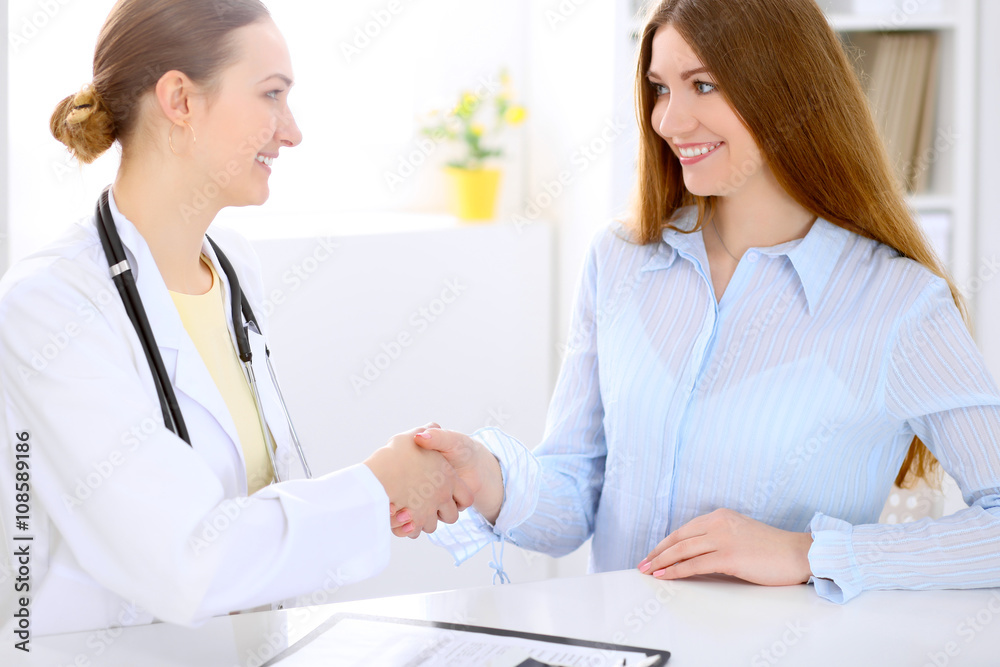 Doctor and  patient  sitting at the desk near window, sun shines