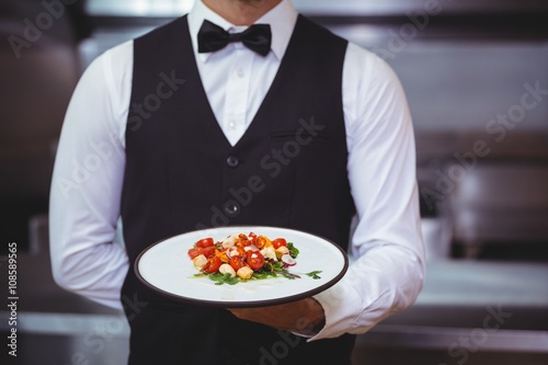 Handsome waiter holding a plate photo