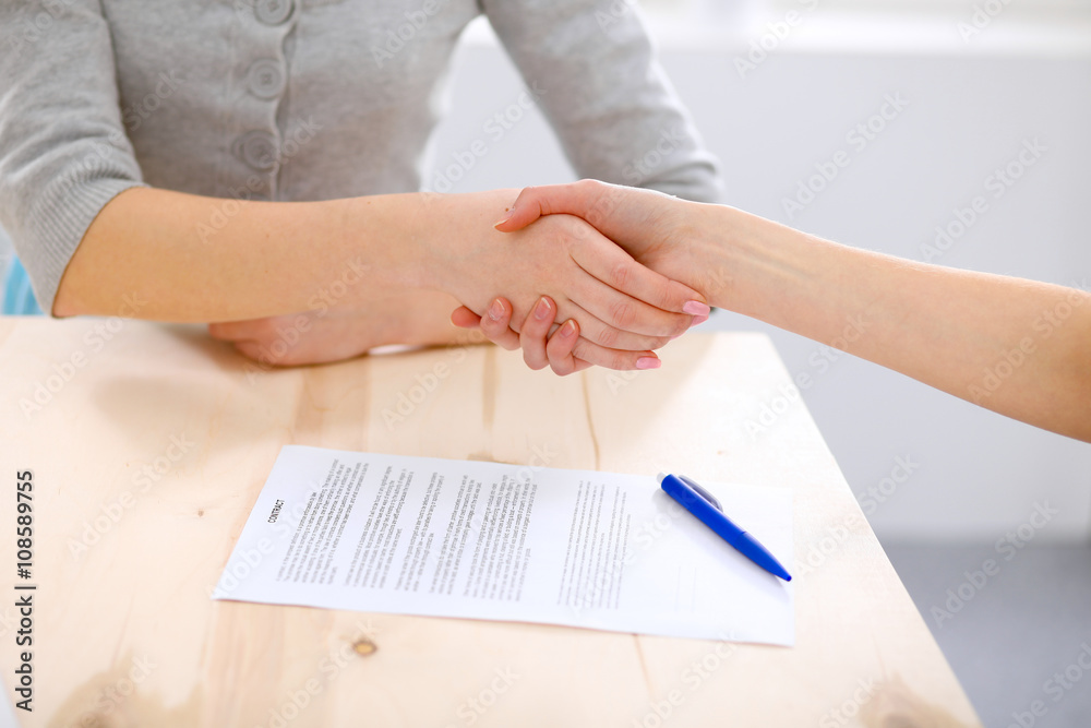 Young business woman shaking hands  after signing contract