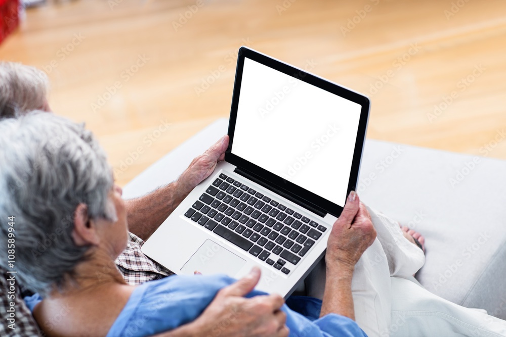 Senior couple using a digital tablet on sofa Senior couple using a digital tablet on sofa