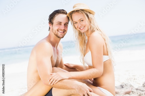 Portrait of young couple sitting together on the beach