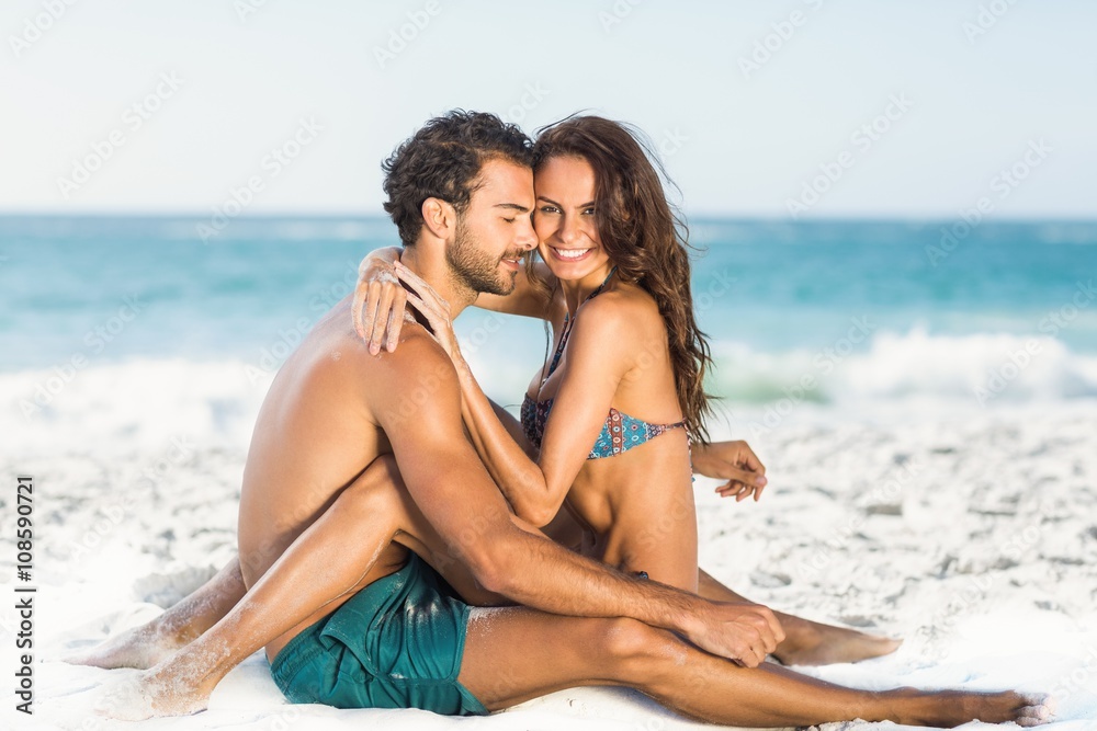 Cute couple hugging sitting on the beach