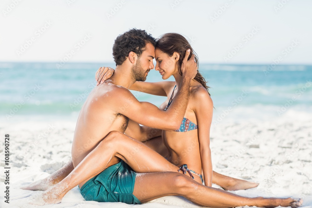Cute couple hugging sitting on the beach 